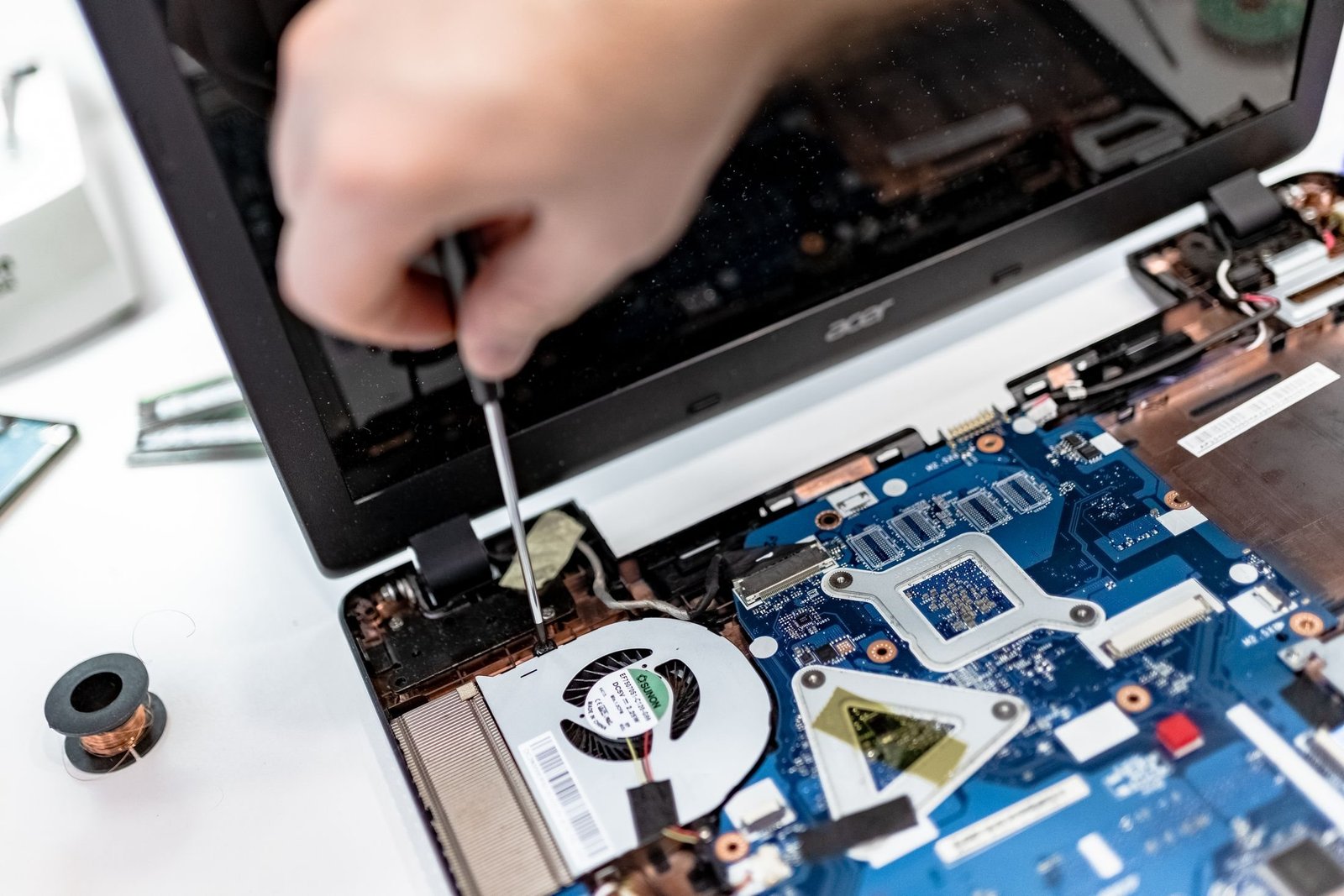 Technician inspecting components inside an open laptop